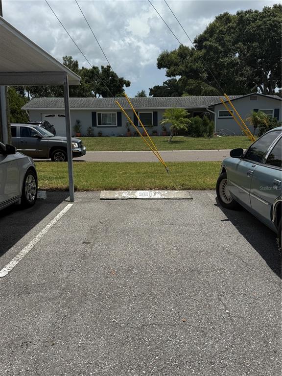 A view from a parking space looking toward a single-story house across a street — 5725 12TH AVENUE N UNIT 306D, ST PETERSBURG, FL