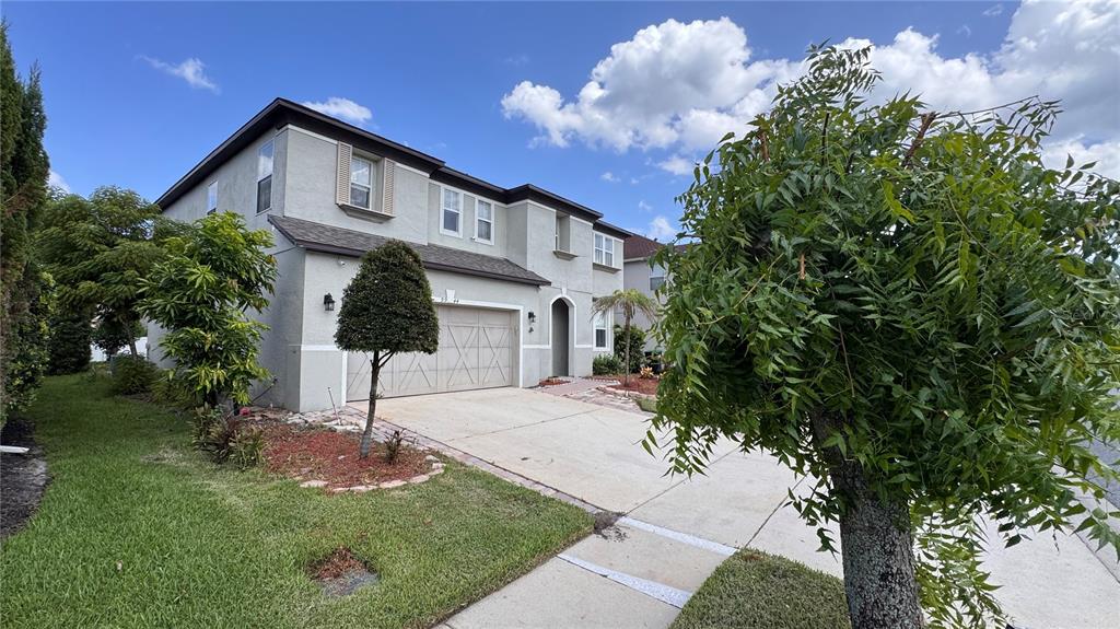 A two-story stucco house with a two-car garage and a front yard — 9944 CHORLTON CIRCLE, ORLANDO, FL