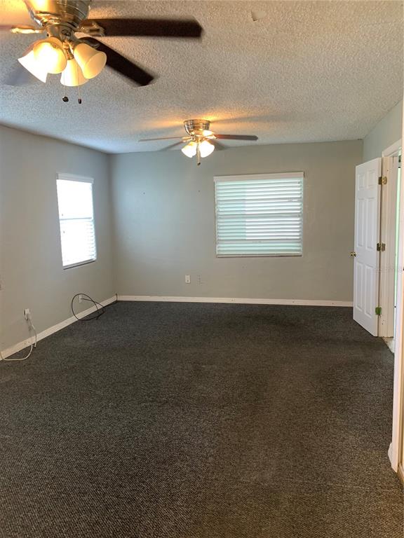 A bedroom with gray carpet, two ceiling fans, and two windows with white blinds — 1023 W GORE STREET W, ORLANDO, FL