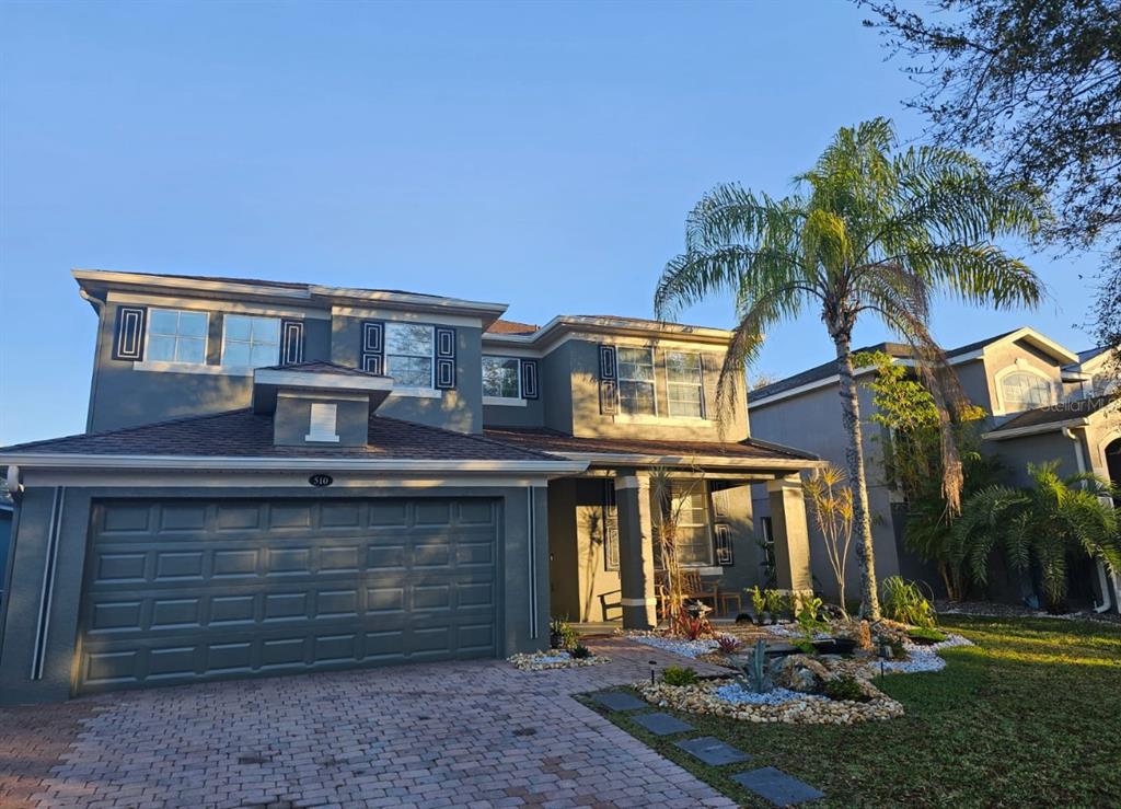 A two-story house with a gray exterior, a two-car garage, and a palm tree — 510 BROOKESHIRE DRIVE, DAVENPORT, FL