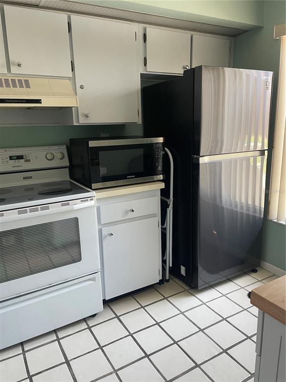 A kitchen features white cabinets, a white stove, a microwave, and a black refrigerator — 6382 PALMA DEL MAR BOULEVARD S UNIT 222, ST PETERSBURG, FL