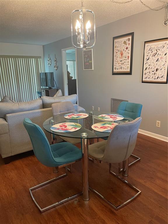 A dining area features a glass-topped table with four chairs and a modern pendant light — 6382 PALMA DEL MAR BOULEVARD S UNIT 222, ST PETERSBURG, FL