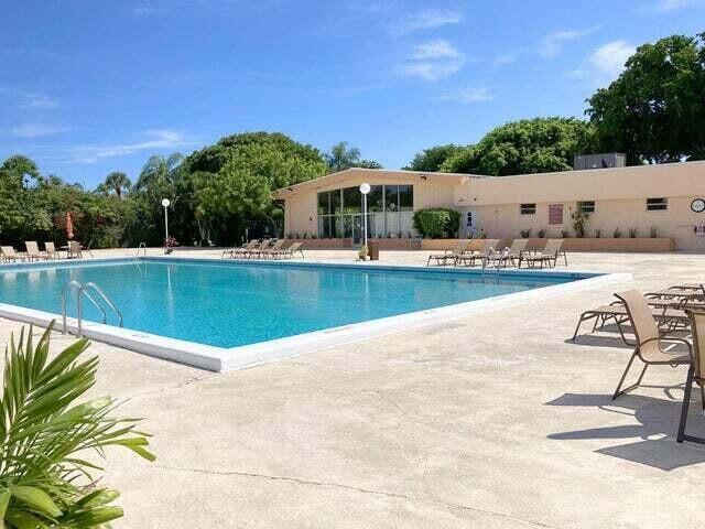 A rectangular swimming pool sits on a concrete deck in front of a low-rise building — 480 Executive Center Drive # 4a, West Palm Beach FL 33401, WEST PALM BEACH, FL