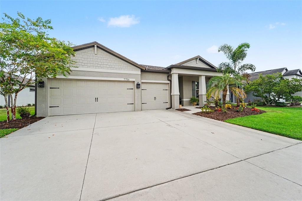A kitchen and dining area with dark wood cabinets, granite countertops, and a round table — 7756 YALE HARBOR DRIVE, WESLEY CHAPEL, FL