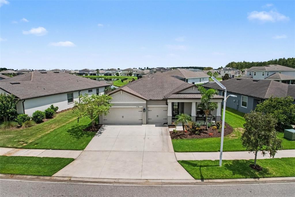 A covered patio features a dining area, wicker furniture, a television, and a screened-in view — 7756 YALE HARBOR DRIVE, WESLEY CHAPEL, FL
