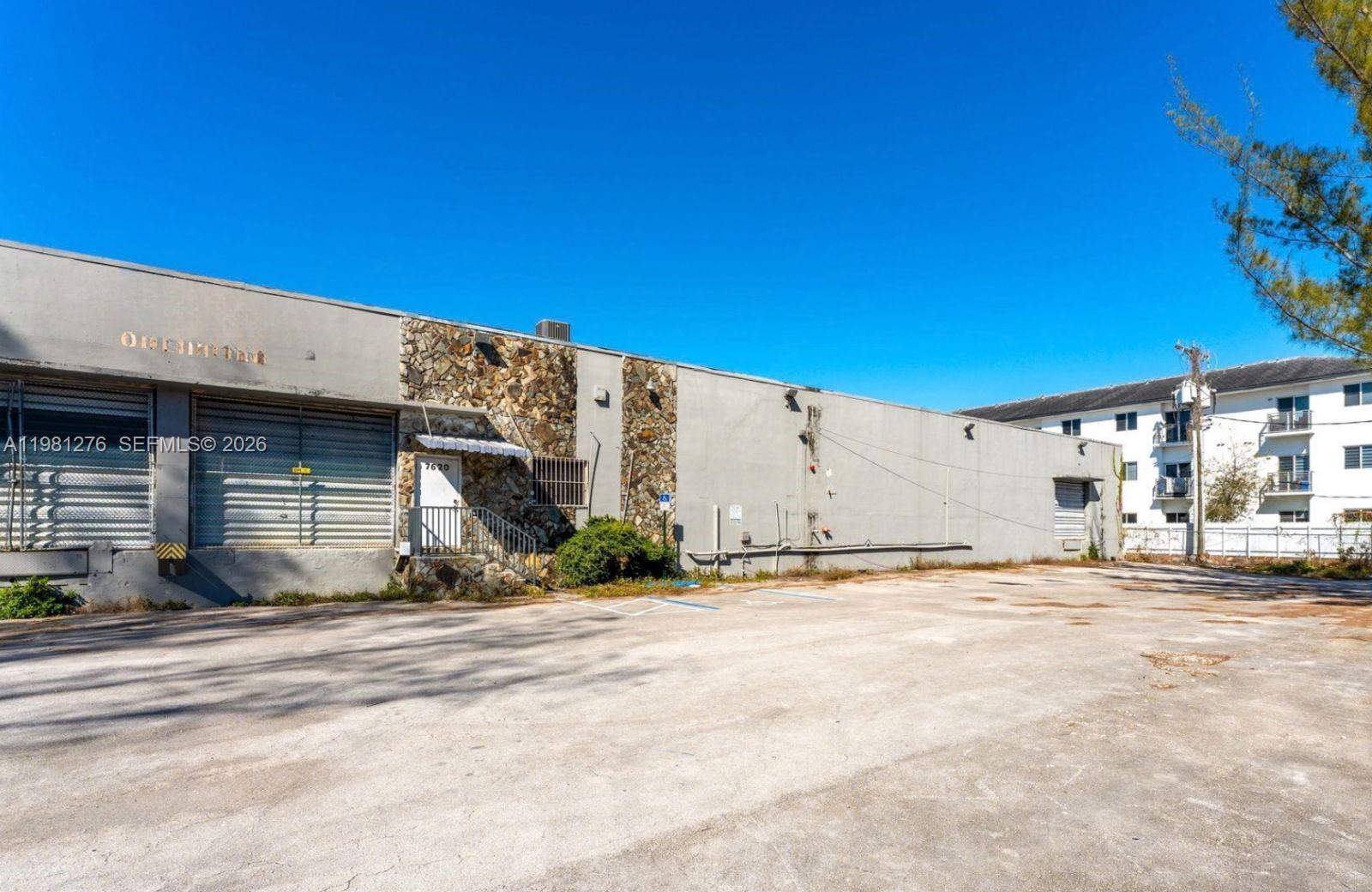 A low-rise commercial building with a stone-accented entrance and a large paved parking lot — 7620 W 2nd Ct, Hialeah FL 33014, HIALEAH, FL