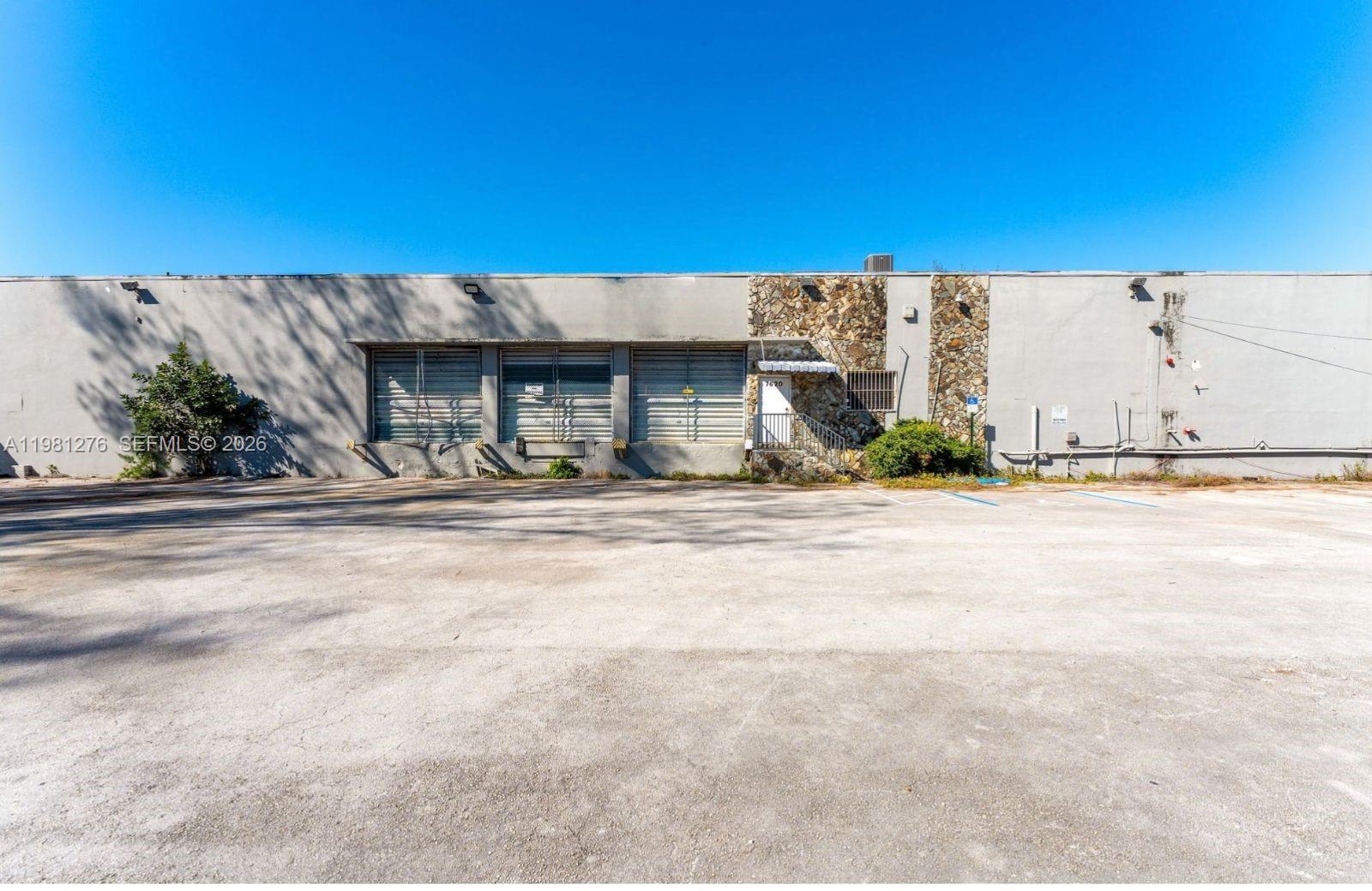 A single-story industrial building features a concrete facade, three loading bays, and stone accents — 7620 W 2nd Ct, Hialeah FL 33014, HIALEAH, FL