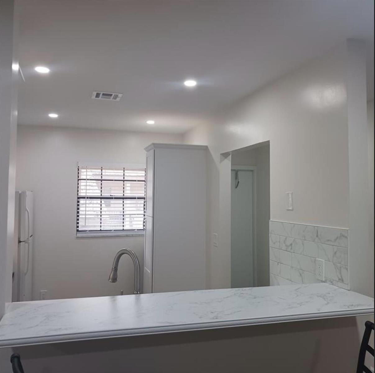 A kitchen features white cabinets, a marble-patterned countertop, and a window with blinds — 3689 NW 94th Avenue # 51, Sunrise FL 33351, SUNRISE, FL