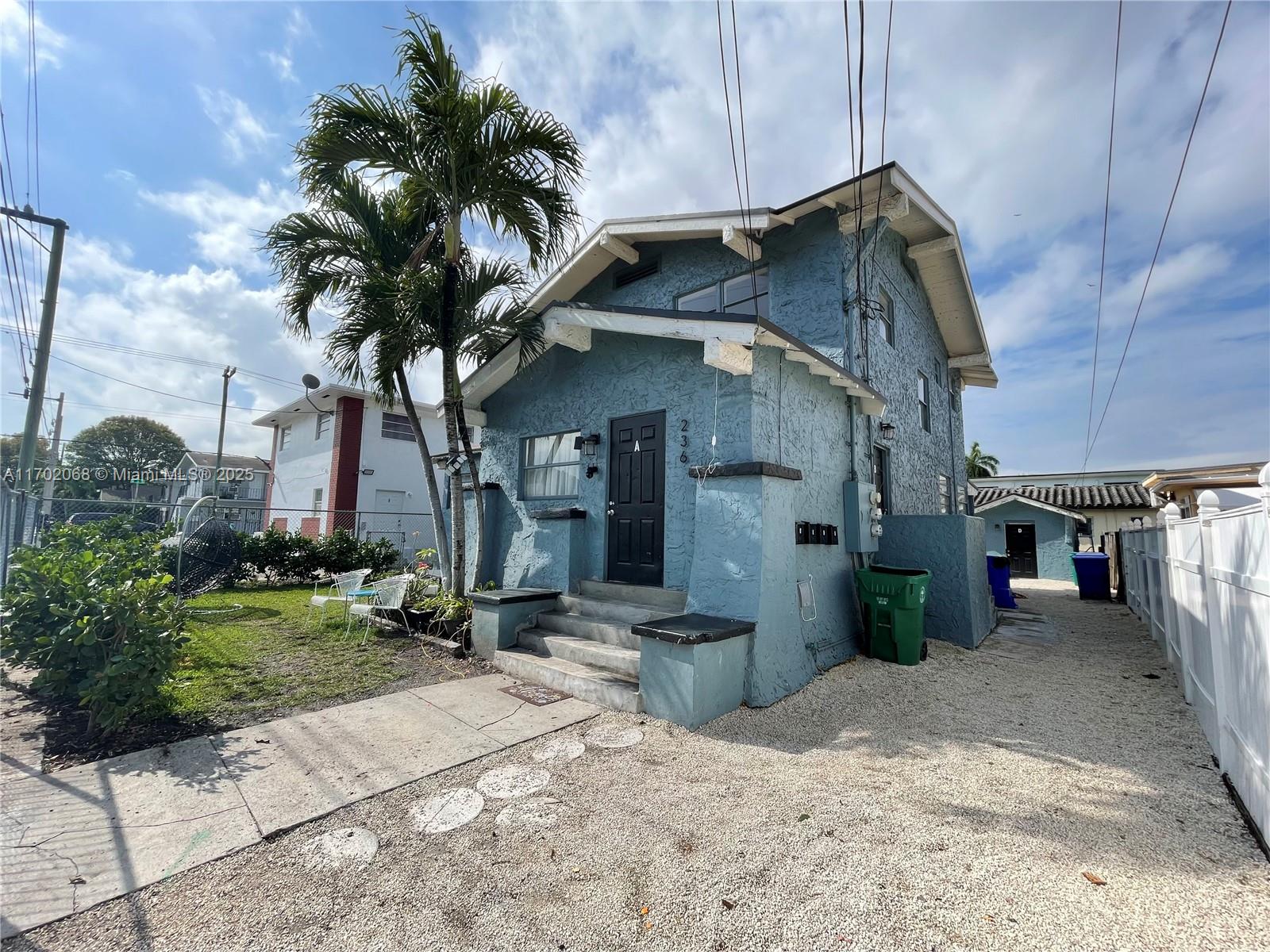 A blue, two-story stucco house features a black front door and a gravel driveway — 236 SW 10 Avenue, Miami FL 33130, MIAMI, FL