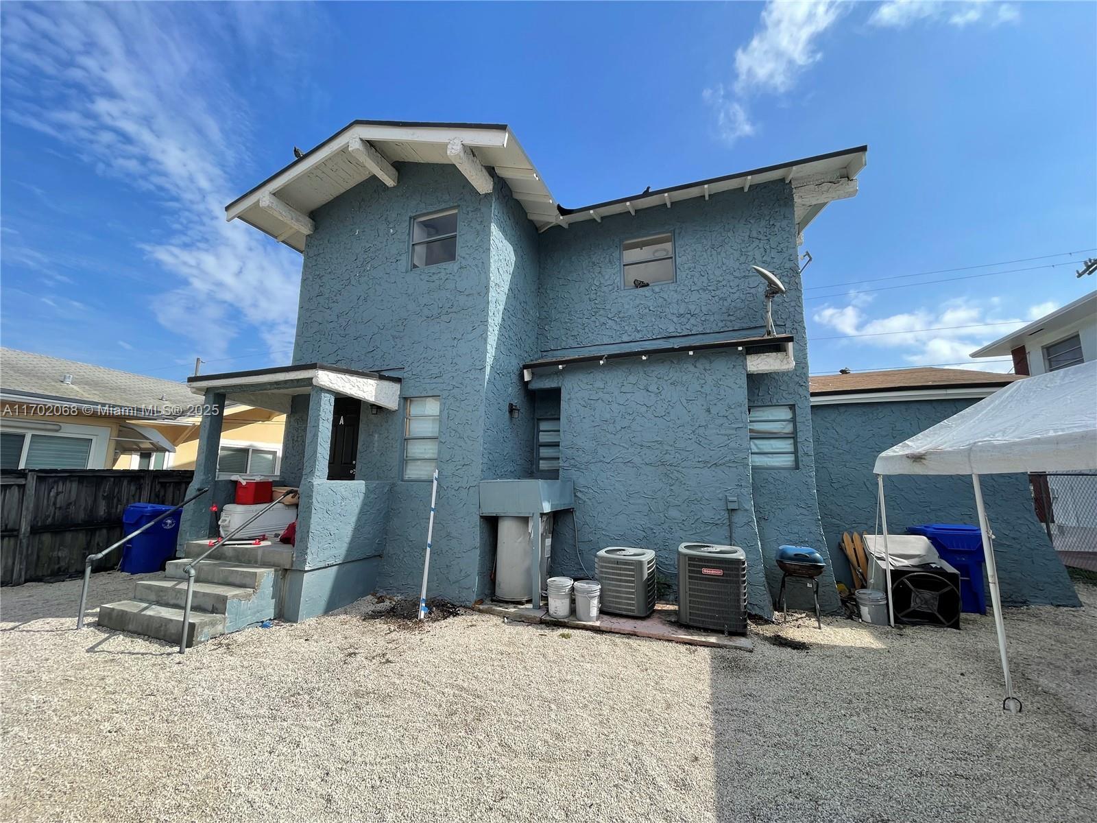 The exterior of a two-story blue stucco house features a gravel yard and two air-conditioning units — 236 SW 10 Avenue, Miami FL 33130, MIAMI, FL