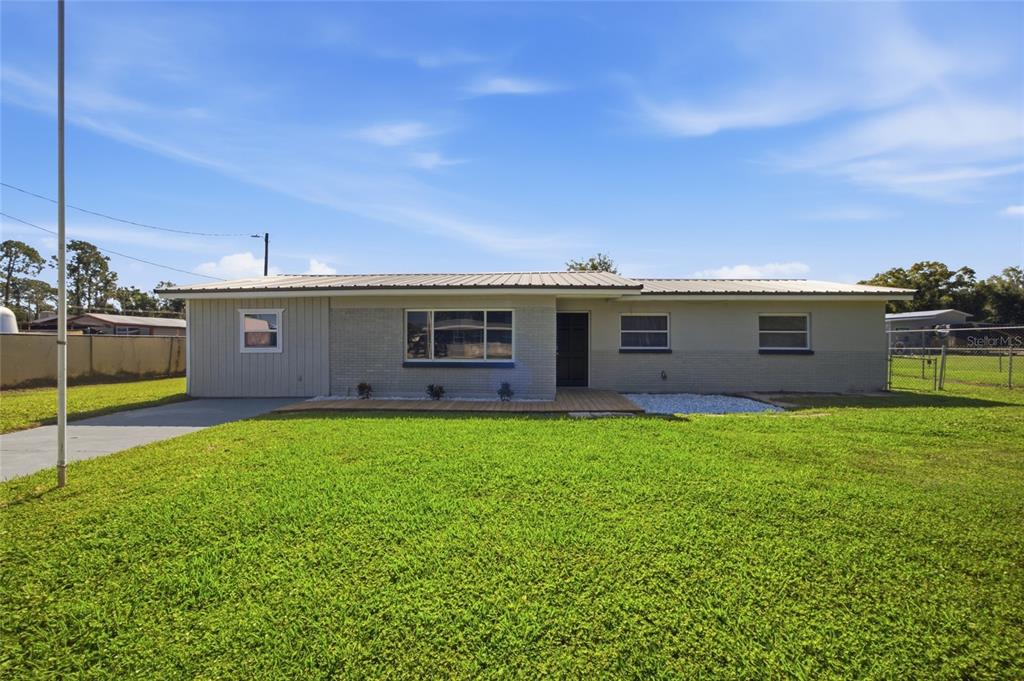 A single-story house with a metal roof, brick facade, and a large front lawn — 3502 LILES LANE, PLANT CITY, FL