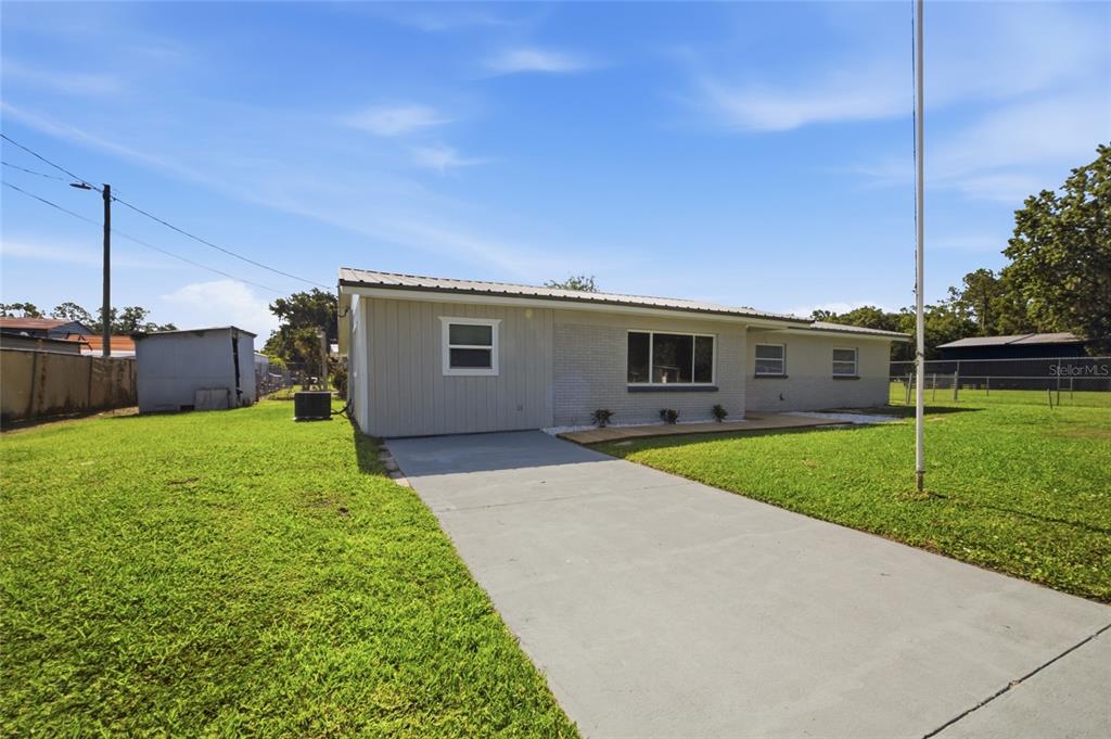 A single-story house with a light-colored exterior and a metal roof sits on a lawn — 3502 LILES LANE, PLANT CITY, FL