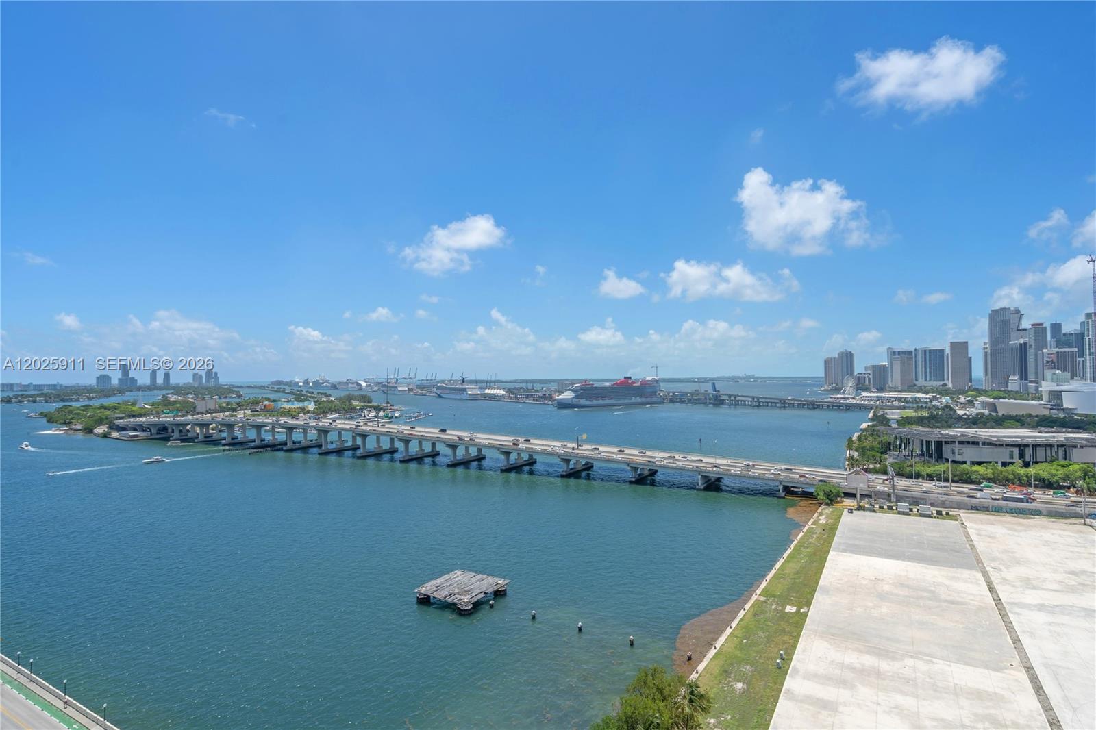 An elevated view shows a bridge spanning a bay with cruise ships and city buildings — 555 NE 15th St # 23I, Miami FL 33132, MIAMI, FL