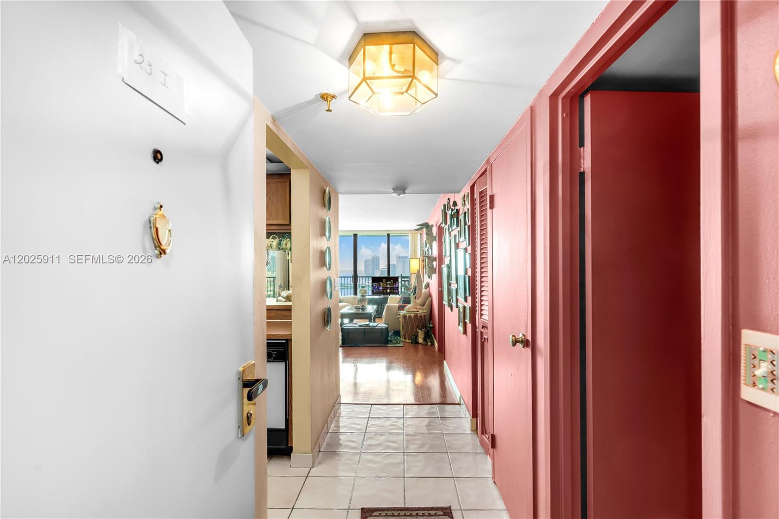 A tiled entryway leads into a living area with hardwood floors and a balcony view — 555 NE 15th St # 23I, Miami FL 33132, MIAMI, FL