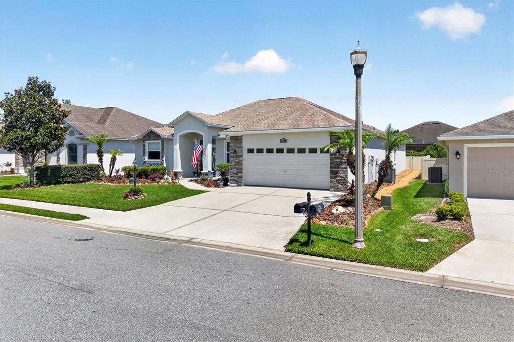A single-story suburban house with a two-car garage, stone accents, and a paved driveway — 6420 EVERGREEN PARK DRIVE, LAKELAND, FL