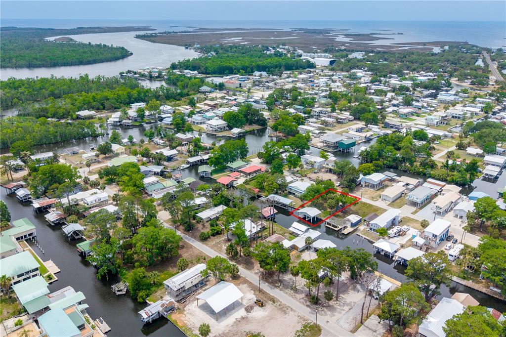 An aerial view shows a waterfront house with a boat dock outlined in red — 75 NE 236TH STREET, SUWANNEE, FL