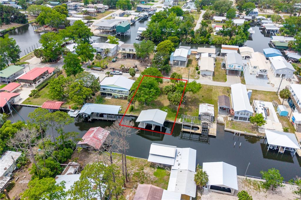 An aerial view shows a waterfront lot with a boat dock and red outline — 75 NE 236TH STREET, SUWANNEE, FL