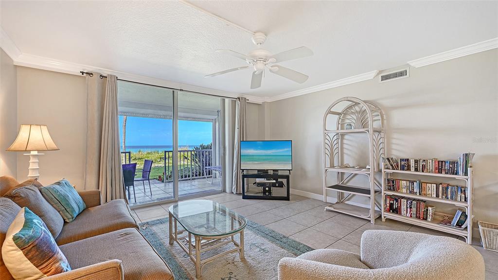 A living room features tile floors, a ceiling fan, and sliding doors overlooking the ocean — 4325 GULF OF MEXICO DRIVE UNIT 103, LONGBOAT KEY, FL