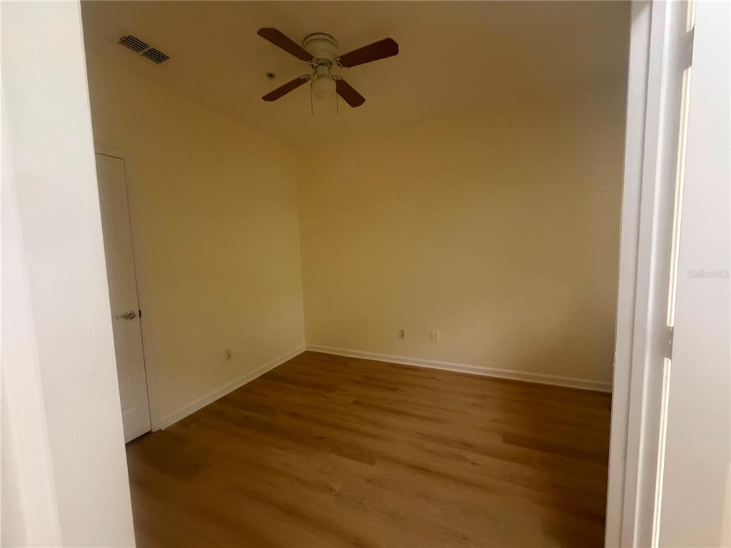 An empty room with light-colored walls, wood-look flooring, and a ceiling fan — 2525 SAN TECLA STREET UNIT 106, ORLANDO, FL