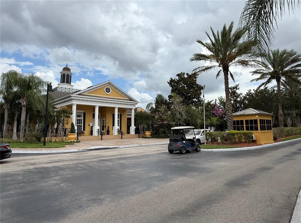 A yellow clubhouse with a cupola and a portico stands near a small guardhouse — 3725 CONROY ROAD UNIT 2127, ORLANDO, FL
