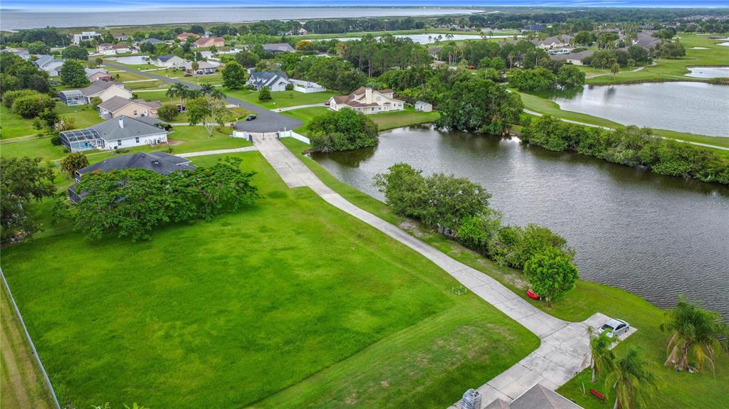 An aerial view shows a large vacant residential lot next to a lake and houses — 2959 MONICA TERRACE, KISSIMMEE, FL