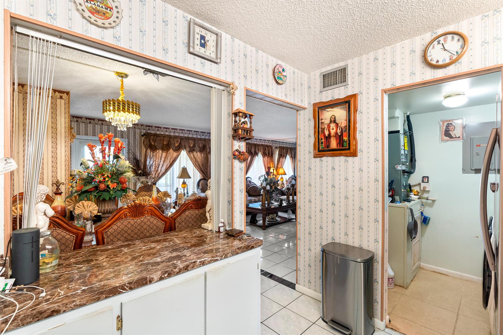 A kitchen pass-through window overlooks a dining area next to a utility room and hallway — 4996 Sable Pine Circle # A1, West Palm Beach FL 33417, WEST PALM BEACH, FL