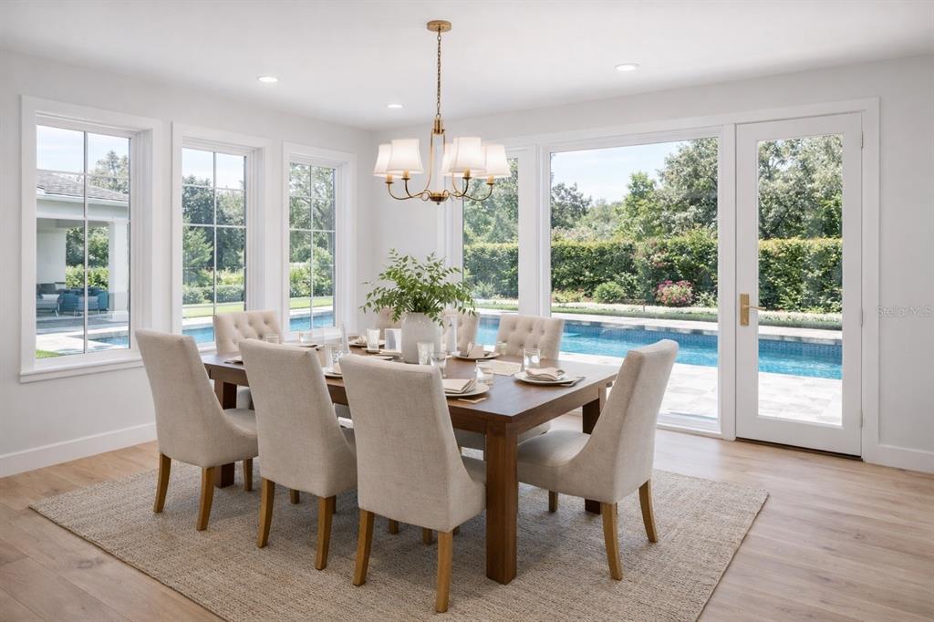 A dining room with a wooden table, upholstered chairs, a chandelier, and a pool view — 1106 SARAH MATHEWS DRIVE, OAKLAND, FL