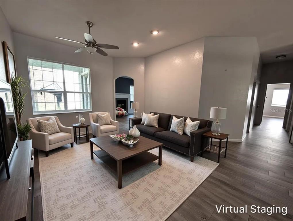 A living room with gray walls, wood-look flooring, a ceiling fan, and virtual furniture staging — 4009 NW 67TH PLACE, GAINESVILLE, FL
