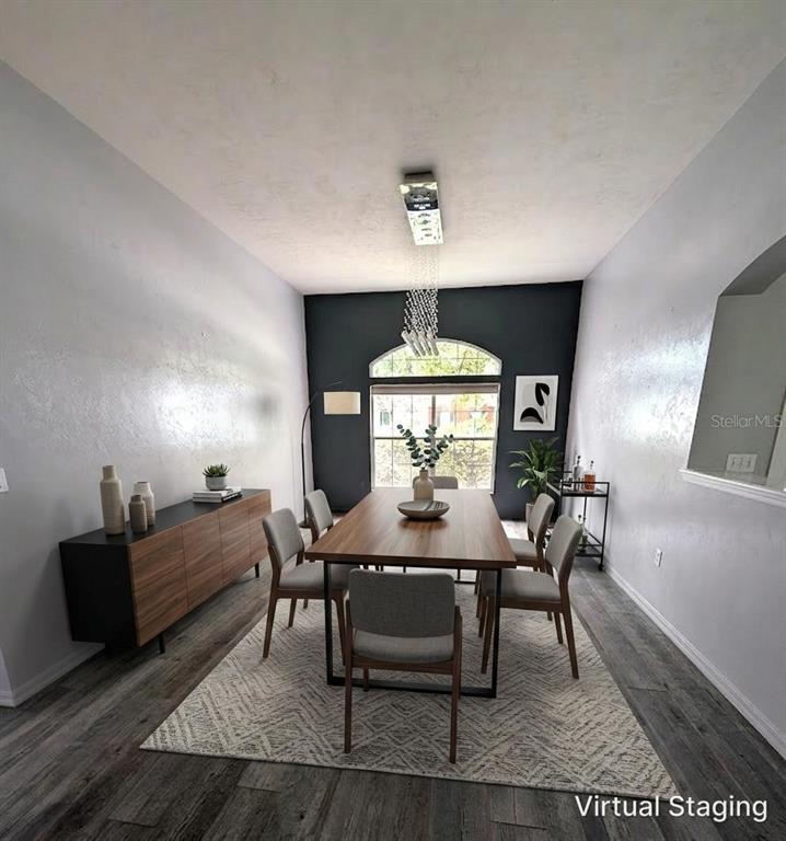 A dining room features a wooden table, grey chairs, a sideboard, and a dark accent wall — 4009 NW 67TH PLACE, GAINESVILLE, FL