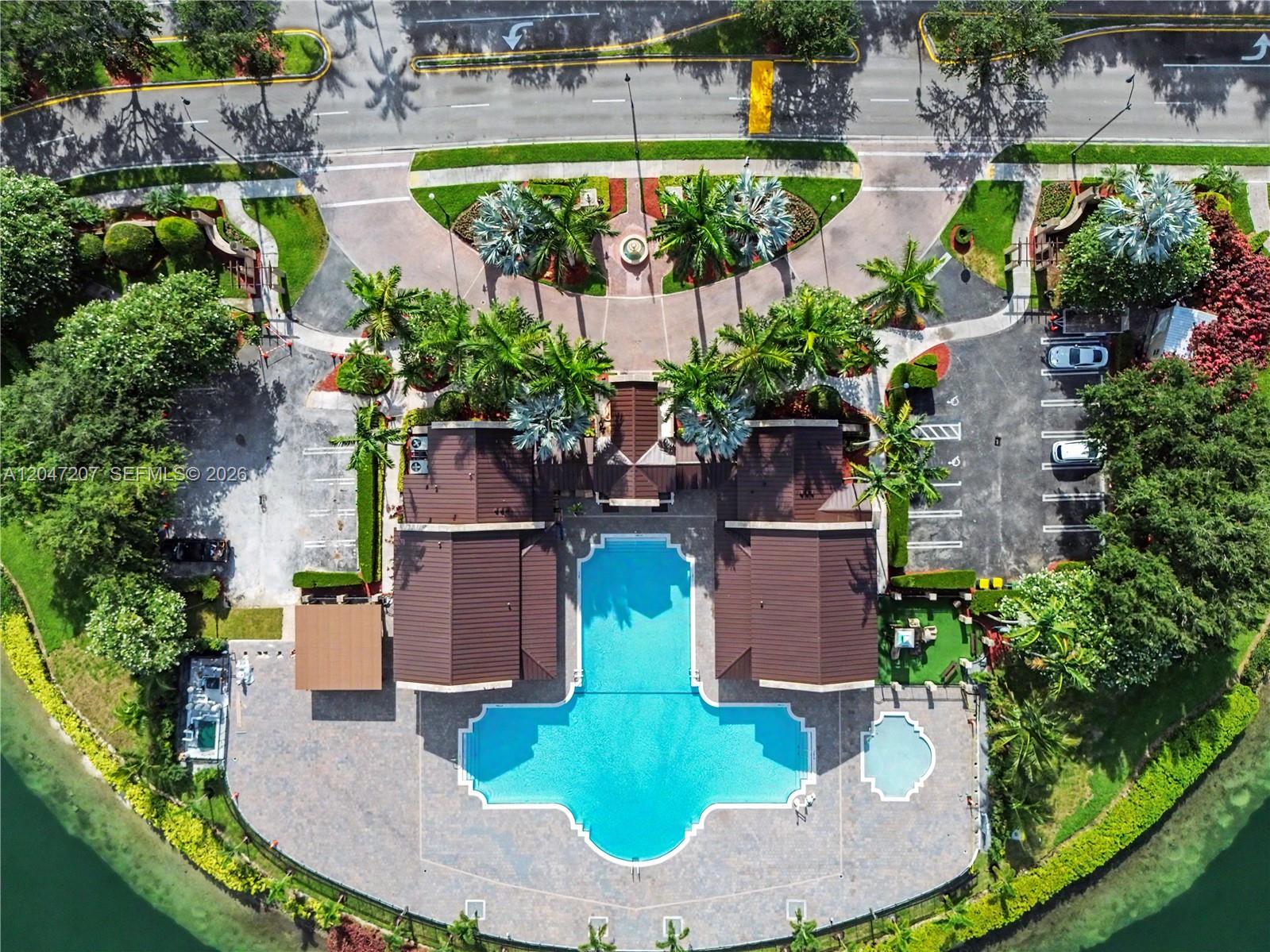 An aerial view shows a community pool area with a clubhouse, parking, and landscaping — 1555 NE 33rd Rd # 2, Homestead FL 33033, HOMESTEAD, FL