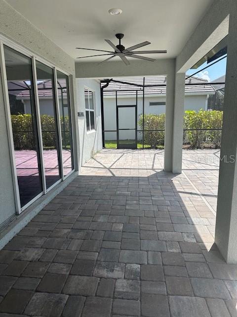 A covered patio features paver flooring, a ceiling fan, and a screened-in enclosure — 3360 CHESTERTOWN LOOP, BRADENTON, FL