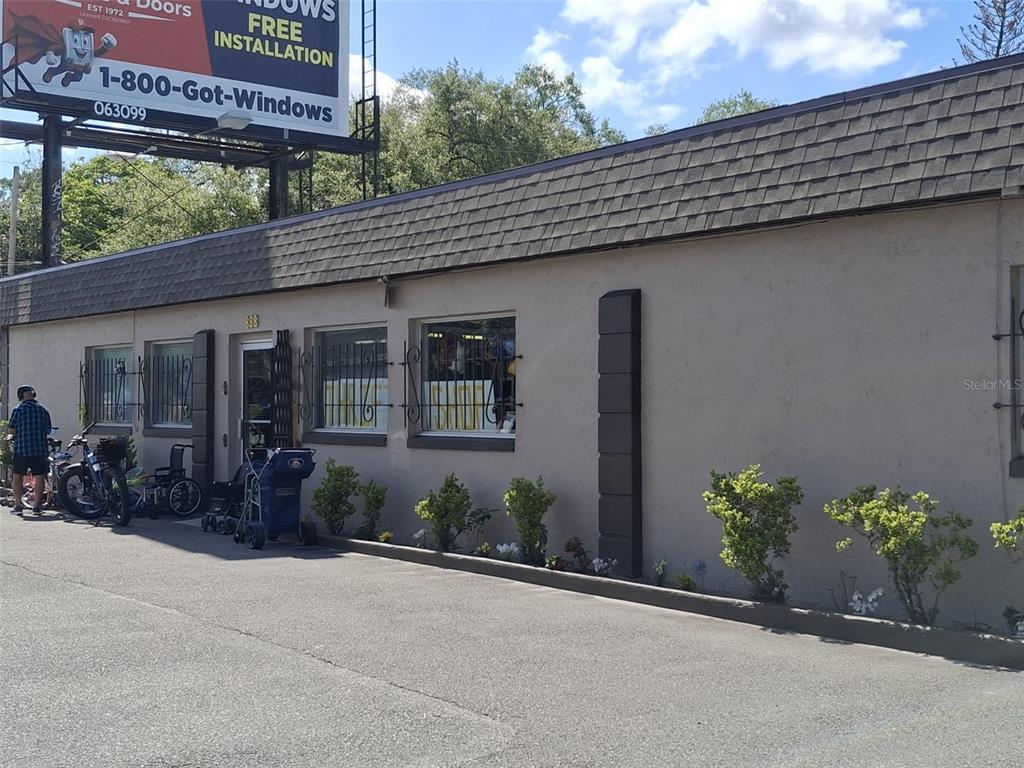 A single-story commercial building with a tan stucco exterior and a dark shingled roof — 884 E MICHIGAN STREET, ORLANDO, FL