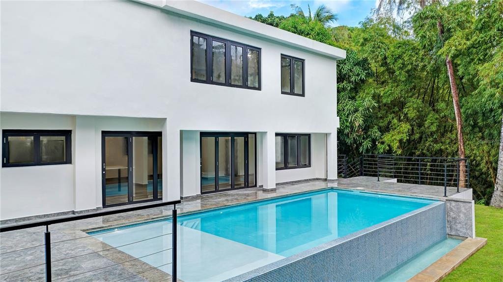 A white two-story house features a rectangular swimming pool with a tiled infinity edge — 15 SAN ISAAC STREET, SAN JUAN, PR