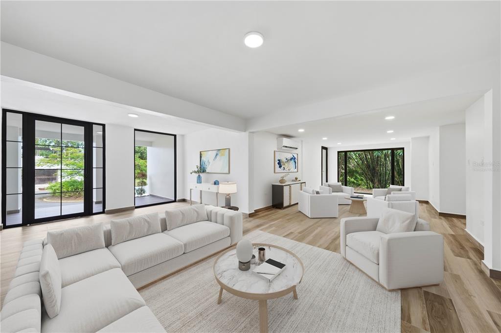 A spacious, modern living room features white sofas, a marble coffee table, and large windows — 15 SAN ISAAC STREET, SAN JUAN, PR