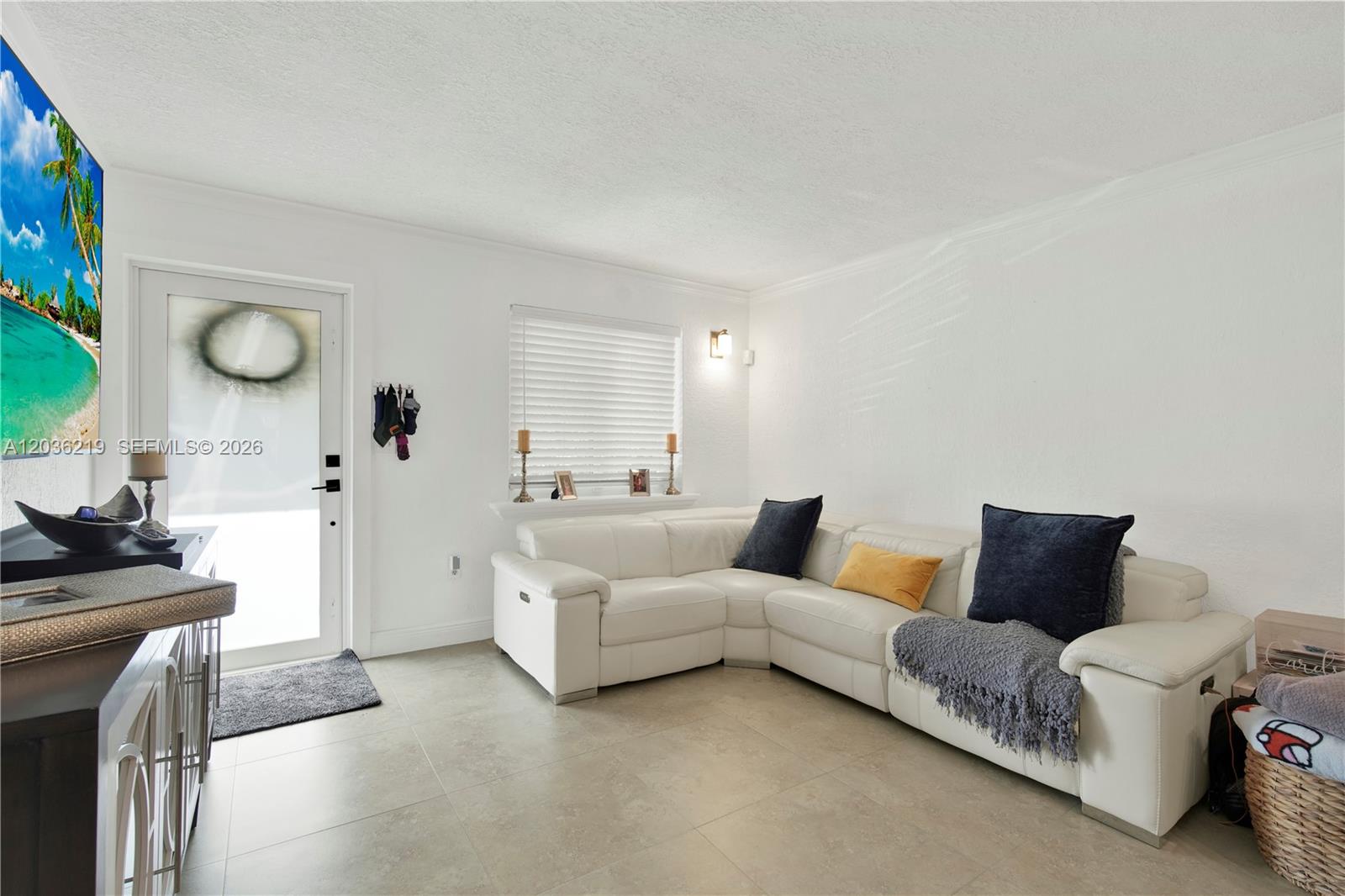 A living room features a white sectional sofa, tile flooring, and a glass-paneled entry door — 4260 SW 68th Ct, Miami FL 33155, MIAMI, FL