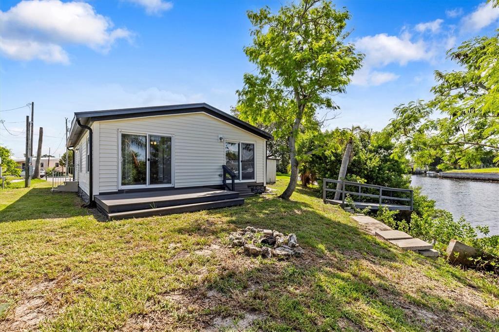 A single-story house with a deck and a small dock overlooking a canal — 13147 CABIN COURT, HUDSON, FL