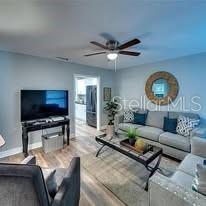 A living room features a grey sofa, a television on a stand, and a ceiling fan — 120 AVENIDA DE BAHA, NOKOMIS, FL