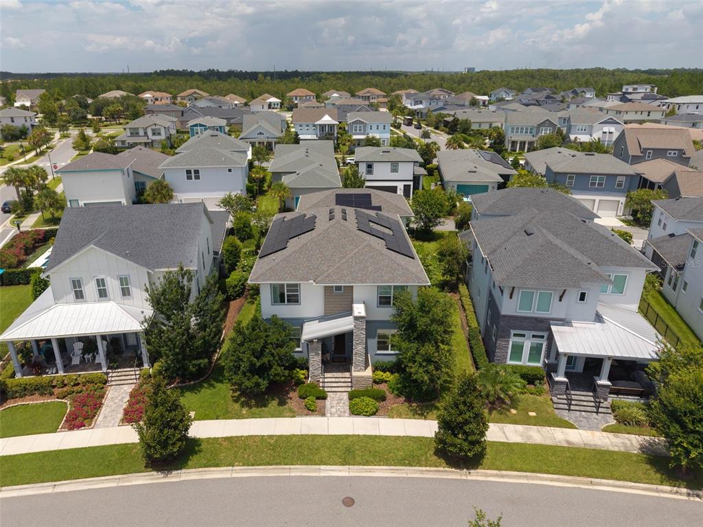 An aerial view shows a two-story suburban house with solar panels on the roof — 6921 ARNOLDSON STREET, ORLANDO, FL