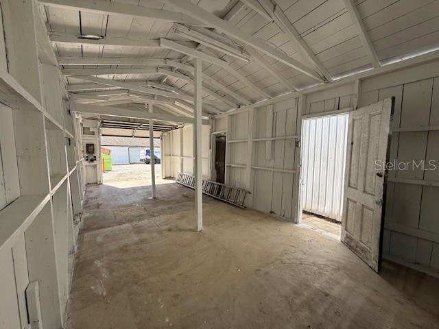 An interior view of a rustic, white-painted wooden shed with an open garage-style entrance — 323 N DELAWARE AVENUE UNIT 3, DELAND, FL