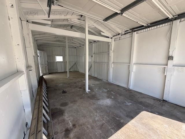 An interior view of a white, unfinished garage with a concrete floor and exposed framing — 323 N DELAWARE AVENUE UNIT 3, DELAND, FL
