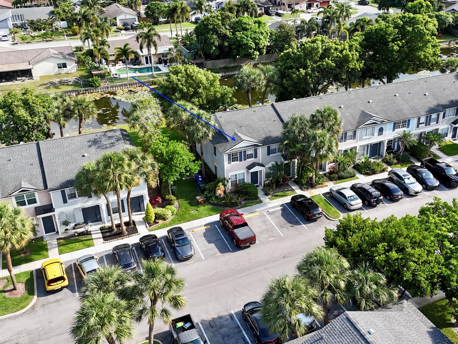 An aerial view shows a two-story townhouse with a parking lot and a pond — 5336 Jubilee Way # 189, Margate FL 33063, MARGATE, FL