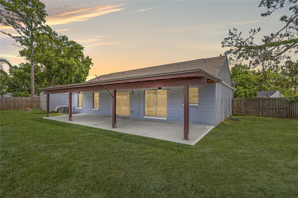 A view of a backyard featuring a concrete patio covered by a wooden pergola — 8913 WOOD LAKE COURT, NEW PORT RICHEY, FL