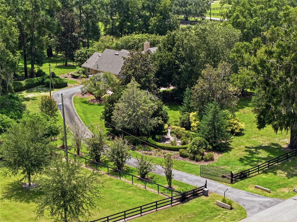 An aerial view shows a house with a long driveway and fenced yard — 26341 NW 166TH AVENUE, HIGH SPRINGS, FL