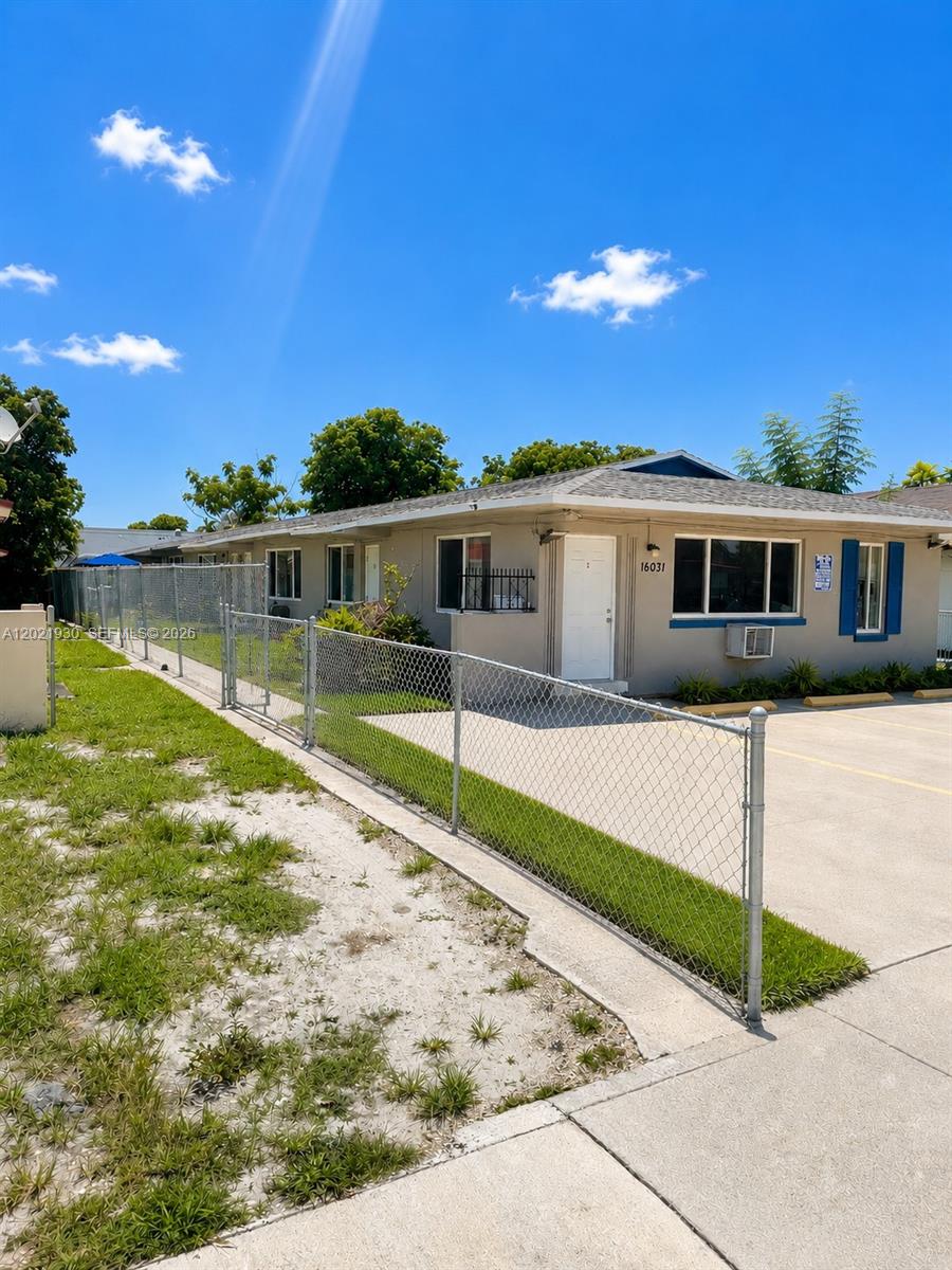 A single-story building with a chain-link fence and a concrete parking area in front — 16031 NE 19th Pl, North Miami Beach FL 33162, NORTH MIAMI BEACH, FL