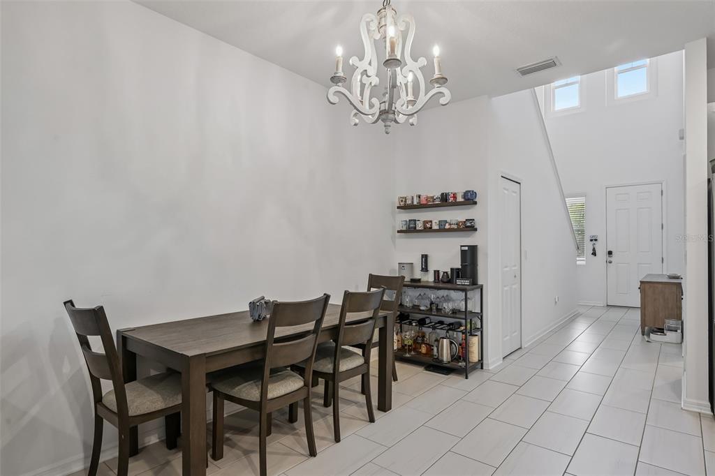 A dining area features a wooden table, four chairs, a chandelier, and a bar cart — 5518 LOS ROBLES COURT, PALMETTO, FL