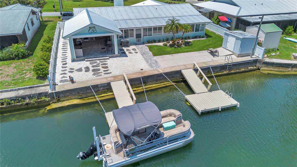 An aerial view shows a waterfront house with a boat dock and a pontoon boat — 1409 SE 4TH AVENUE, CRYSTAL RIVER, FL