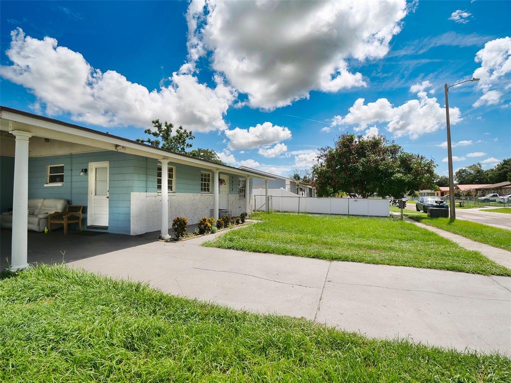 A light blue single-story house features a concrete driveway, a covered porch, and a lawn — 7018 GLENVIEW DRIVE, TAMPA, FL
