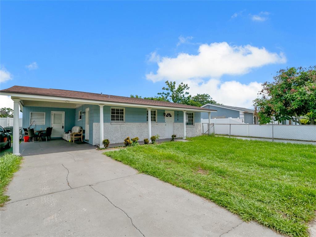 A single-story house with a blue exterior, a carport, and a front lawn — 7018 GLENVIEW DRIVE, TAMPA, FL