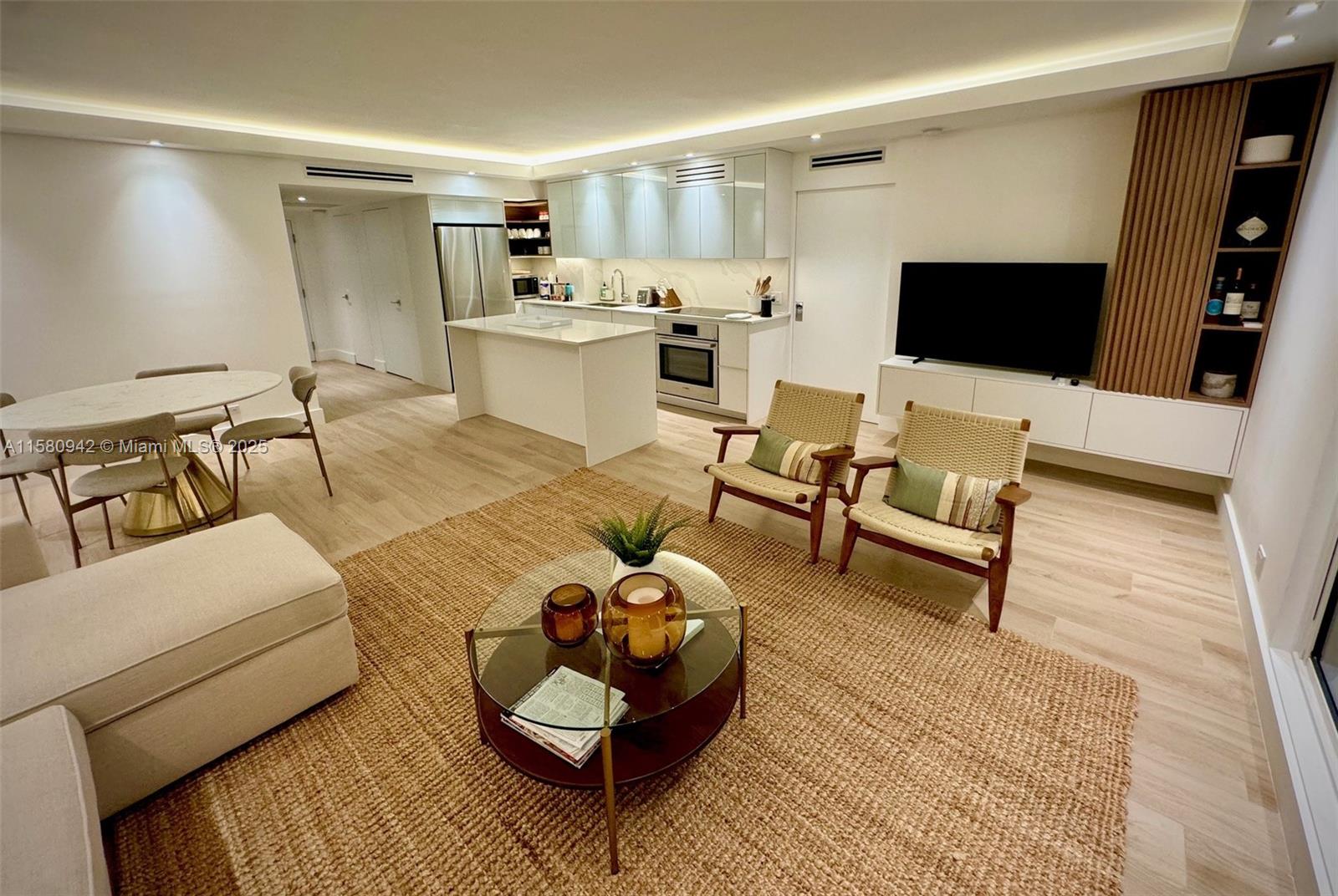 This open-concept living area features a modern kitchen, dining space, and a neutral color palette — 2301 Collins Ave # 837, Miami Beach FL 33139, MIAMI BEACH, FL