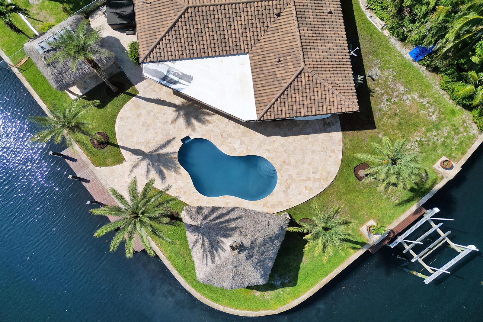 Aerial view of a house with a pool, tiki hut, and dock on a canal — 271 SE 5th Terrace, Pompano Beach FL 33060, POMPANO BEACH, FL